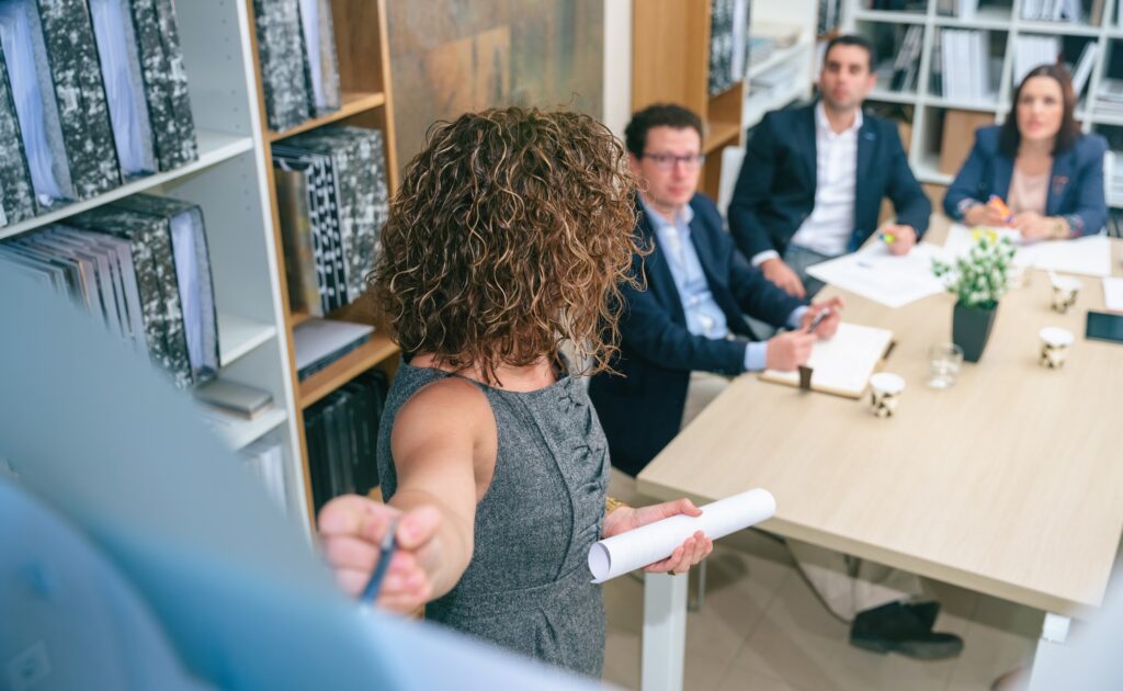 Female coach explaining project to business team in headquarters